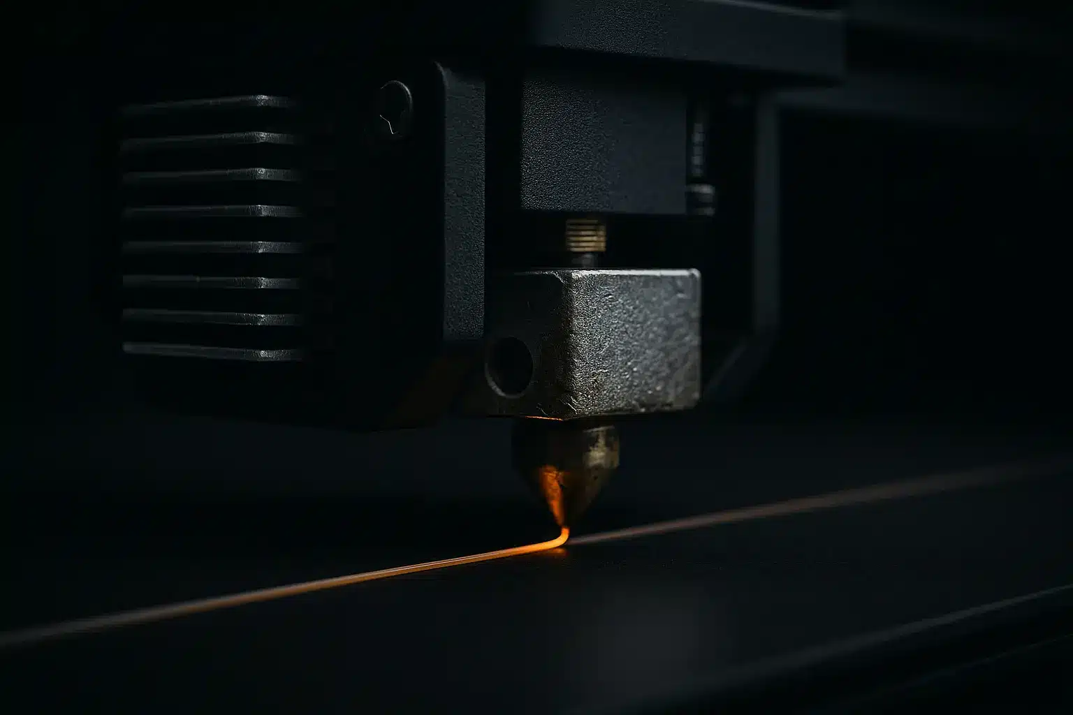 Nahaufnahme eines FDM-3D-Druckkopfs, der einen dünnen orangefarbenen Filamentstrang extrudiert